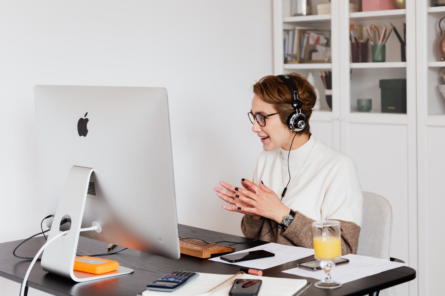 A woman in headphones mid-conversation on a call at her desk